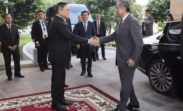 In this photo released by Agence Kampuchea Press (AKP), Chinese Foreign Minister Wang Yi, front right, greets with Cambodia's Foreign Minister, SOK Chenda Sophea, front left, in Phnom Penh, Cambodia, Sunday, April 21, 2024. Wang Yi, arrived Cambodia to mark his 3 days official visit (21-23 April) Cambodia to reaffirm his country's commitment and to boost the already firmly tied to southeast Asian country, twice visited in the last eight months. (AKP via AP)