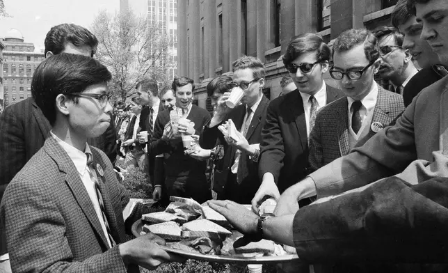 FILE - Columbia University students forming a blockade around Low Memorial Library on the New York City campus, eat sandwiches and drink milk while preventing food from being taken to student demonstrators inside, April 29, 1968. Later, friends of the student protesters were able to throw some food up to them. (AP Photo/Anthony Camerano, File)