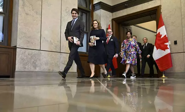 Canada's Prime Minister Justin Trudeau, left, Deputy Prime Minister and Minister of Finance Chrystia Freeland are joined by cabinet ministers for a photo before the tabling of the federal budget on Parliament Hill in Ottawa, Ontario, on Tuesday, April 16, 2024. (Justin Tang/The Canadian Press via AP)