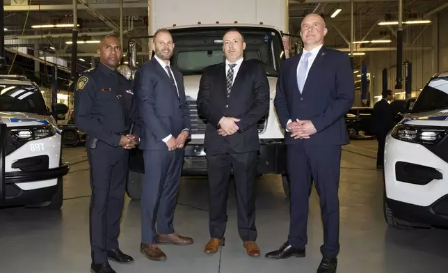 Chief Nishan Duraiappah, left to right, Detective Sergeant Mike Mavity, Peel Regional Police Det. Gord Oakes and ATF Special Agent in Charge, Eric DeGree pose in front of a recovered truck during a press conference regarding Project 24K a joint investigation into the theft of gold from Pearson International Airport, in Brampton, Ontario, on Wednesday, April 17, 2024. (Arlyn McAdorey/The Canadian Press via AP)