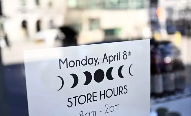 A graphic of an eclipse is seen on a business' special store hours, a day before a total solar eclipse will be visible in Kingston, Ontario, Sunday, April 7, 2024. (Justin Tang/The Canadian Press via AP)