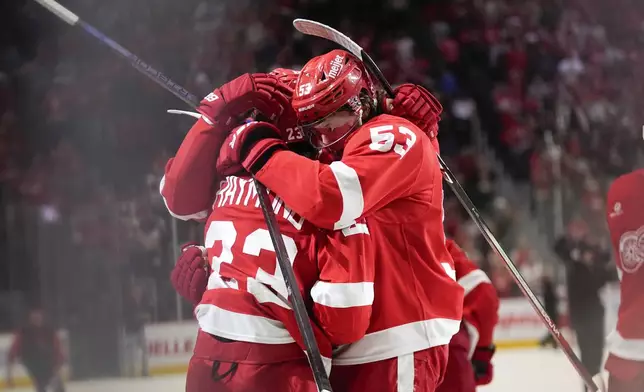 Detroit Red Wings left wing Lucas Raymond (23) celebrates with Moritz Seider (53) after his goal against the Montreal Canadiens in overtime during an NHL hockey game Monday, April 15, 2024, in Detroit. (AP Photo/Paul Sancya)