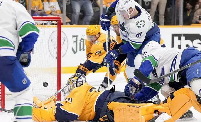 Nashville Predators goaltender Juuse Saros (74) lets a Vancouver Canucks goal score at the the end of the third period to tie the game during Game 4 of an NHL hockey Stanley Cup first-round playoff series Sunday, April 28, 2024, in Nashville, Tenn. (AP Photo/George Walker IV)