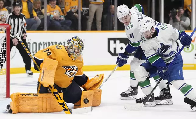 Nashville Predators goaltender Juuse Saros (74) blocks a shot on goal by Vancouver Canucks right wing Conor Garland (8) during the third period in Game 4 of an NHL hockey Stanley Cup first-round playoff series Sunday, April 28, 2024, in Nashville, Tenn. (AP Photo/George Walker IV)