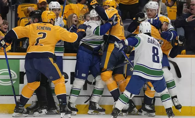 Nashville Predators Luke Schenn (2), Michael McCarron (47) and Ryan McDonagh, right, fight with Vancouver Canucks center Dakota Joshua (81), J.T. Miller (9), Nikita Zadorov (91) and Conor Garland (8) during the first period in Game 3 of an NHL hockey Stanley Cup first-round playoff series Friday, April 26, 2024, in Nashville, Tenn. (AP Photo/George Walker IV)