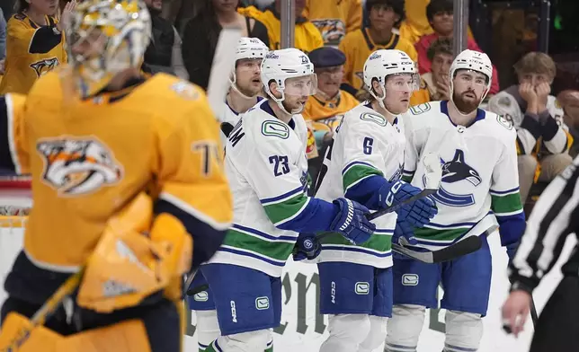 Vancouver Canucks right wing Brock Boeser (6) celebrates his goal against the Nashville Predators with teammates during the third period in Game 4 of an NHL hockey Stanley Cup first-round playoff series Sunday, April 28, 2024, in Nashville, Tenn. (AP Photo/George Walker IV)