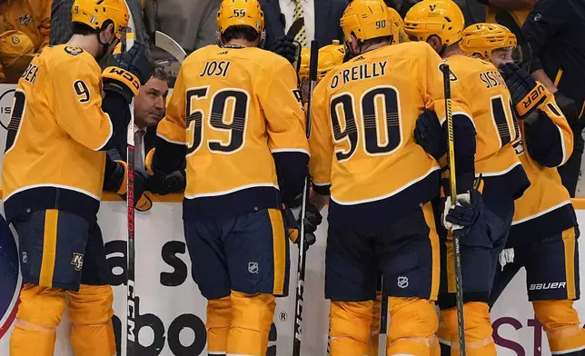 Nashville Predators head coach Andrew Brunette, second from left, talks to his players in a timeout during the third period against the Vancouver Canucks in Game 3 of an NHL hockey Stanley Cup first-round playoff series Friday, April 26, 2024, in Nashville, Tenn. The Canucks won 2-1. (AP Photo/George Walker IV)