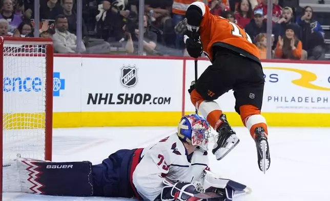 Philadelphia Flyers' Travis Konecny, right, cannot get the puck past Washington Capitals' Charlie Lindgren during the second period of an NHL hockey game, Tuesday, April 16, 2024, in Philadelphia. (AP Photo/Matt Slocum)