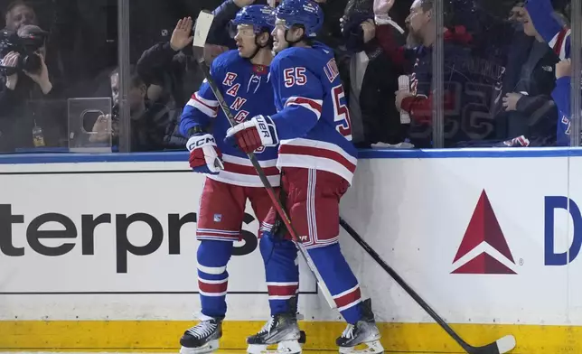 New York Rangers' Artemi Panarin, left, celebrates after his goal with Ryan Lindgren during the second period in Game 1 of an NHL hockey Stanley Cup first-round playoff series against the Washington Capitals, Sunday, April 21, 2024, in New York. (AP Photo/Seth Wenig)