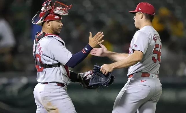 St. Louis Cardinals pitcher Ryan Helsley, right, is congratulated by catcher Willson Contreras after the team's victory against the Oakland Athletics in a baseball game in Oakland, Calif., Tuesday, April 16, 2024. (AP Photo/Tony Avelar)