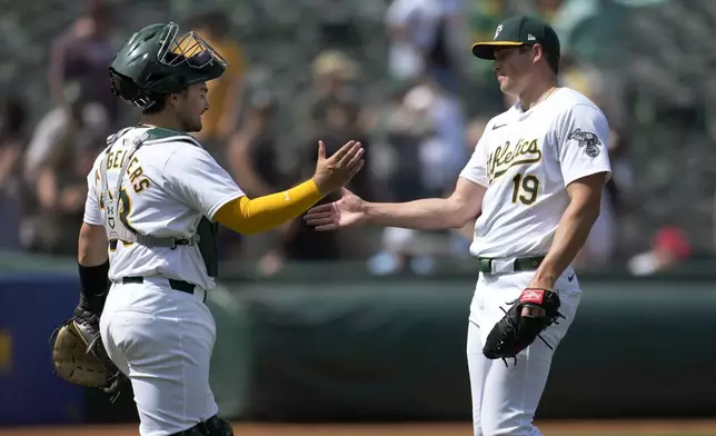 Oakland Athletics catcher Shea Langeliers, left, celebrates with pitcher Mason Miller after the Athletics defeated the St. Louis Cardinals in a baseball game in Oakland, Calif., Wednesday, April 17, 2024. (AP Photo/Jeff Chiu)