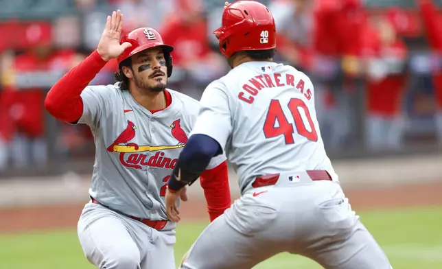 St. Louis Cardinals' Nolan Arenado, left, and Willson Contreras (40) celebrate after scoring against the New York Mets during the first inning of a baseball game, Saturday, April 27, 2024, in New York. (AP Photo/Noah K. Murray)