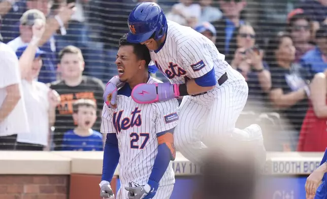 New York Mets Mark Vientos (27), left, celebrates with Harrison Bader after hitting a walk-off home run during the 11th inning of a baseball game against the St. Louis Cardinals at Citi Field, Sunday, April 28, 2024, in New York. (AP Photo/Seth Wenig)