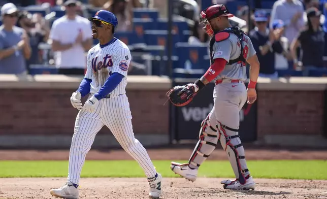 New York Mets' Francisco Lindor, left, reacts after hitting a solo home run while St. Louis Cardinals catcher Iván Herrera looks on during the sixth inning of a baseball game at Citi Field, Sunday, April 28, 2024, in New York. (AP Photo/Seth Wenig)