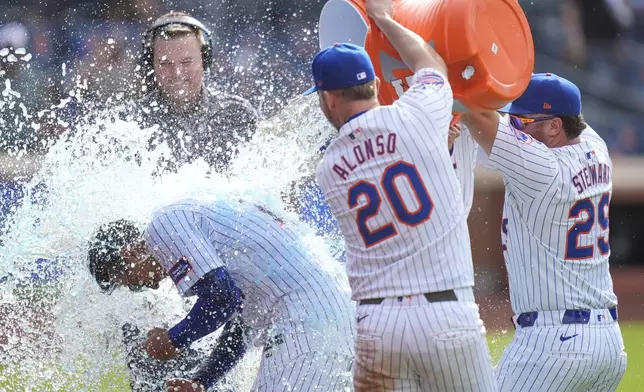 Teammates douse New York Mets Mark Vientos, bottom left, with Gatorade after he hit a walk-off home run during the 11th inning of a baseball game against the St. Louis Cardinals at Citi Field, Sunday, April 28, 2024, in New York. (AP Photo/Seth Wenig)