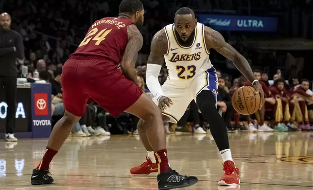 Los Angeles Lakers forward LeBron James (23) dribbles against Cleveland Cavaliers forward Marcus Morris Sr. (24)during the first half of an NBA basketball game Saturday, April 6, 2024, in Los Angeles. (AP Photo/William Liang)