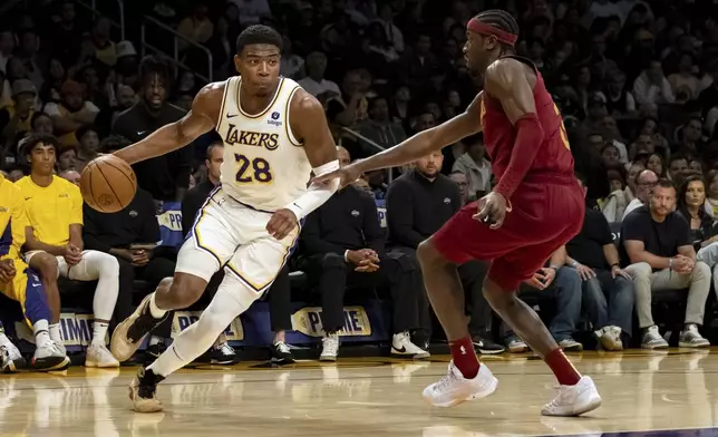 Los Angeles Lakers forward Rui Hachimura (28) drives past Cleveland Cavaliers guard Caris LeVert (3) during the first half of an NBA basketball game Saturday, April 6, 2024, in Los Angeles. (AP Photo/William Liang)