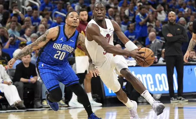 Cleveland Cavaliers guard Caris LeVert, right, drives past Orlando Magic guard Markelle Fultz (20) during the first half of Game 3 of an NBA basketball first-round playoff series Thursday, April 25, 2024, in Orlando, Fla. (AP Photo/John Raoux)