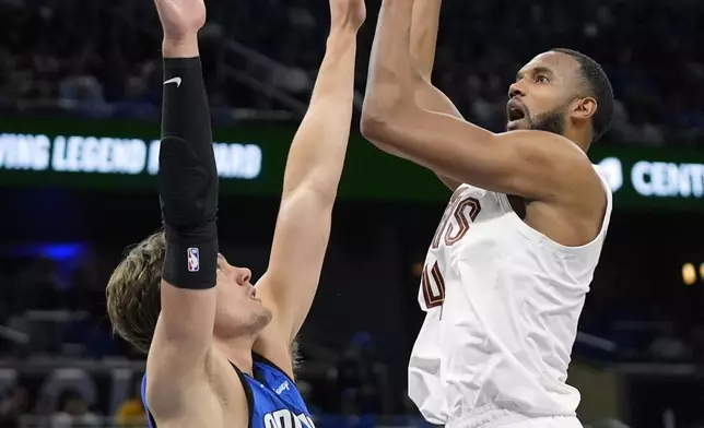 Cleveland Cavaliers forward Evan Mobley, right, shoots over Orlando Magic center Moritz Wagner during the first half of Game 3 of an NBA basketball first-round playoff series Thursday, April 25, 2024, in Orlando, Fla. (AP Photo/John Raoux)