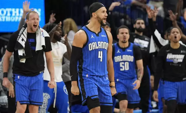 The Orlando Magic bench reacts as guard Jalen Suggs (4) celebrates his 3-point shot against the Cleveland Cavaliers during the first half of Game 3 of an NBA basketball first-round playoff series Thursday, April 25, 2024, in Orlando, Fla. (AP Photo/John Raoux)