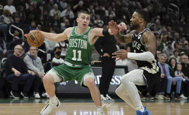Boston Celtics' Payton Pritchard gets past Milwaukee Bucks' Damian Lillard during the first half of an NBA basketball game Tuesday, April 9, 2024, in Milwaukee. (AP Photo/Morry Gash)