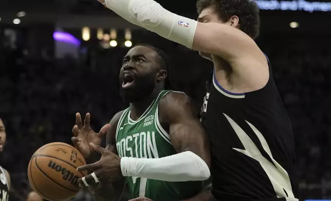 Boston Celtics' Jaylen Brown loses the ball in front of Milwaukee Bucks' Brook Lopez during the first half of an NBA basketball game Tuesday, April 9, 2024, in Milwaukee. (AP Photo/Morry Gash)