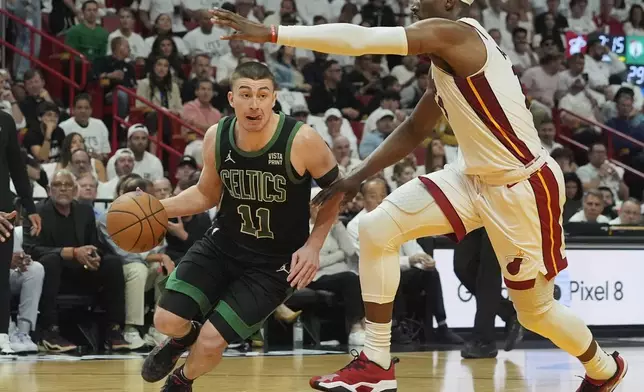Boston Celtics guard Payton Pritchard (11) dribbles around Miami Heat center Bam Adebayo, right, during the first half of Game 4 of an NBA basketball first-round playoff series Monday, April 29, 2024, in Miami. (AP Photo/Marta Lavandier)