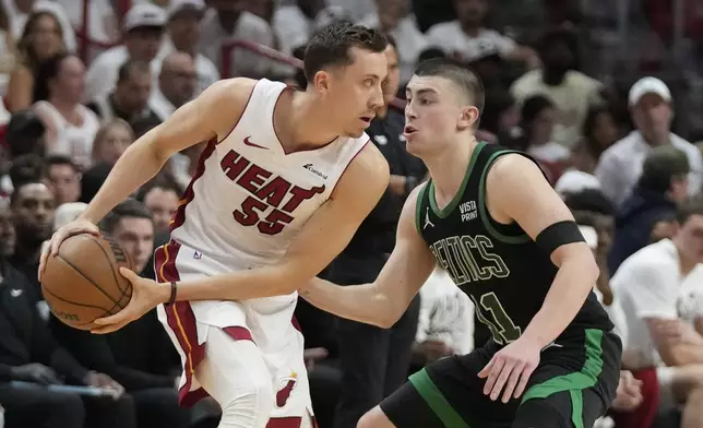 Miami Heat forward Duncan Robinson (55) looks for an opening past Boston Celtics guard Payton Pritchard (11) during the first half of Game 3 of an NBA basketball first-round playoff series, Saturday, April 27, 2024, in Miami. (AP Photo/Wilfredo Lee)