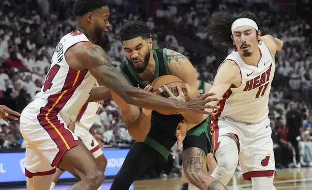 Miami Heat forward Haywood Highsmith (24) and guard Jaime Jaquez Jr. (11) defend Boston Celtics forward Jayson Tatum during the first half of Game 4 of an NBA basketball first-round playoff series, Monday, April 29, 2024, in Miami. (AP Photo/Marta Lavandier)