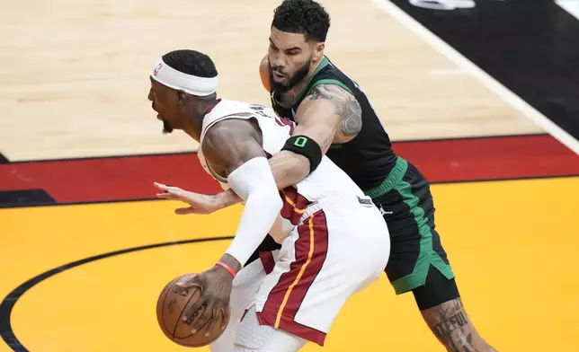 Boston Celtics forward Jayson Tatum (0) attempts to knock the ball away from Miami Heat center Bam Adebayo during the first half of Game 3 of an NBA basketball first-round playoff series, Saturday, April 27, 2024, in Miami. (AP Photo/Wilfredo Lee)