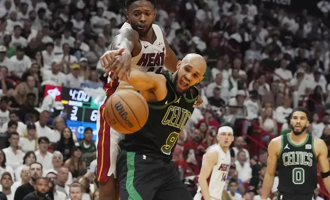Boston Celtics guard Derrick White (9) and Miami Heat forward Haywood Highsmith, top, go after a rebound during the second half of Game 4 of an NBA basketball first-round playoff series, Monday, April 29, 2024, in Miami. (AP Photo/Marta Lavandier)