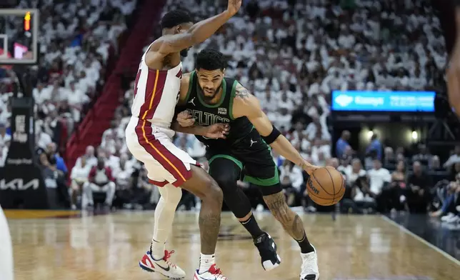 Boston Celtics forward Jayson Tatum, right, drives to the basket against Miami Heat forward Haywood Highsmith during the first half of Game 3 of an NBA basketball first-round playoff series, Saturday, April 27, 2024, in Miami. (AP Photo/Wilfredo Lee)