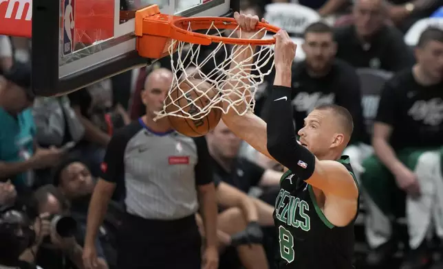 Boston Celtics forward Kristaps Porzingis (8) dunks the ball during the first half of Game 3 of an NBA basketball first-round playoff series against the Miami Heat, Saturday, April 27, 2024, in Miami. (AP Photo/Wilfredo Lee)
