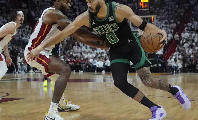 Boston Celtics forward Jayson Tatum (0) dribbles around Miami Heat forward Haywood Highsmith (24) during the first half of Game 4 of an NBA basketball first-round playoff series, Monday, April 29, 2024, in Miami. (AP Photo/Marta Lavandier)