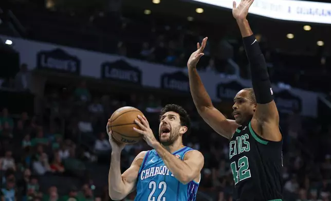 Charlotte Hornets guard Vasa Micic (22) drives to the basket ahead of Boston Celtics center Al Horford (42) during the first half of an NBA basketball game in Charlotte, N.C., Monday, April 1, 2024. (AP Photo/Nell Redmond)