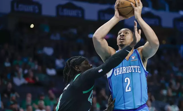 Charlotte Hornets forward Grant Williams (2) shoots over Boston Celtics guard Jrue Holiday during the first half of an NBA basketball game in Charlotte, N.C., Monday, April 1, 2024. (AP Photo/Nell Redmond)