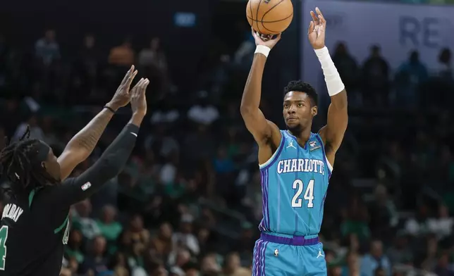 Charlotte Hornets forward Brandon Miller (24) shoots over Boston Celtics guard Jrue Holiday during the first half of an NBA basketball game in Charlotte, N.C., Monday, April 1, 2024. (AP Photo/Nell Redmond)