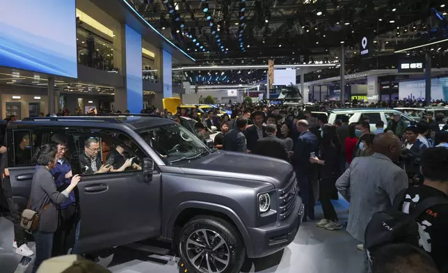 Visitors look at a Great Wall's Haval car during the opening of China Auto Show in Beijing, China, Thursday, April 25, 2024. (AP Photo/Tatan Syuflana)