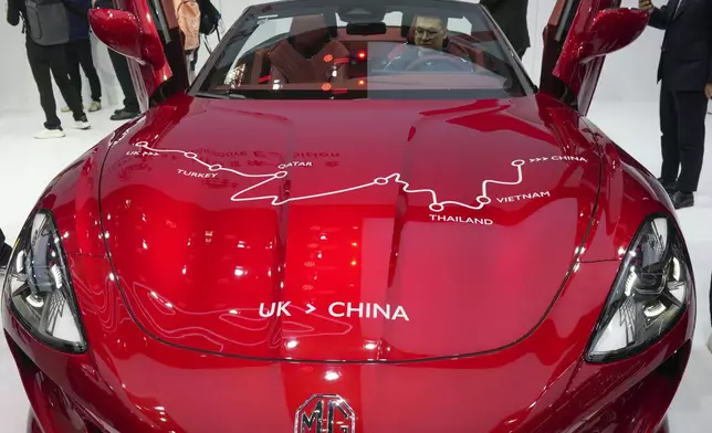 Visitors check at an MG car during the opening of China Auto Show in Beijing, China, Thursday, April 25, 2024. (AP Photo/Tatan Syuflana)