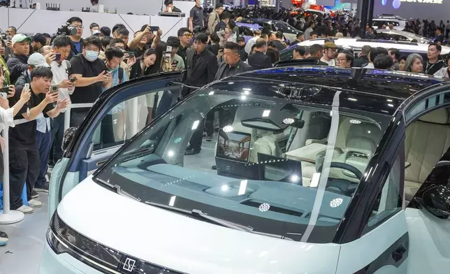 Visitors take photos of a Zeekr car during the opening of China Auto Show in Beijing, China, Thursday, April 25, 2024. (AP Photo/Tatan Syuflana)