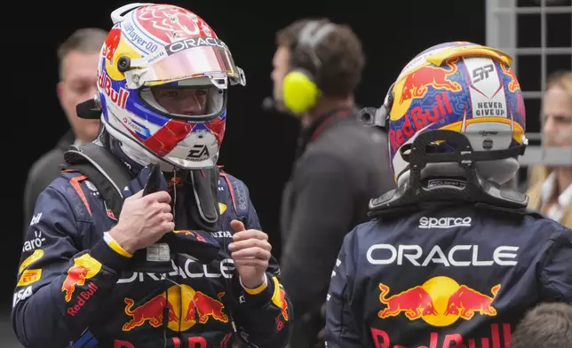 Sprint race winner Red Bull driver Max Verstappen, left, of the Netherlands gestures to third placed teammate Sergio Perez of Mexico at the Chinese Formula One Grand Prix at the Shanghai International Circuit, Shanghai, China, Saturday, April 20, 2024. (AP Photo/Andy Wong)