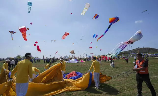 Participants prepare a kite during the 41st International Kite Festival in Weifang, Shandong Province of China, Saturday, April 20, 2024. (AP Photo/Tatan Syuflana)