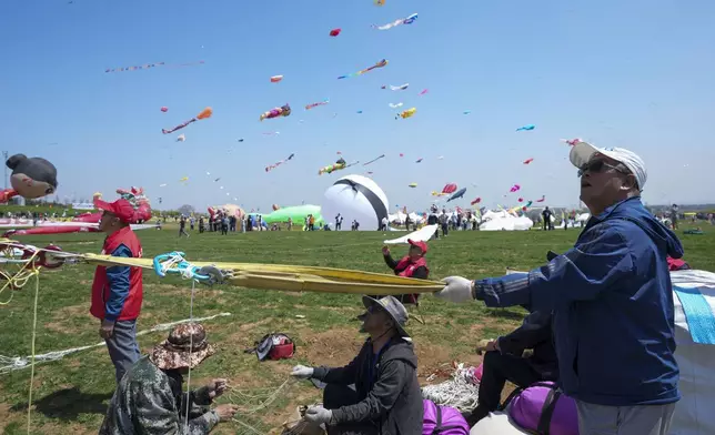 A participant flies a kite at the 41st International Kite Festival in Weifang, Shandong Province of China, Saturday, April 20, 2024. (AP Photo/Tatan Syuflana)