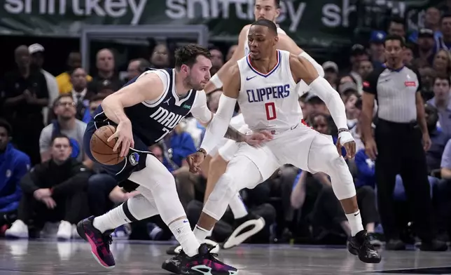 Dallas Mavericks guard Luka Doncic, left, works against Los Angeles Clippers guard Russell Westbrook (0) during the first half in Game 2 of an NBA basketball first-round playoff series in Dallas, Friday, April 26, 2024. (AP Photo/Tony Gutierrez)