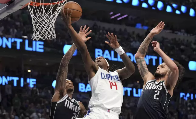 Los Angeles Clippers guard Terance Mann (14) drives to the basket past Dallas Mavericks forward P.J. Washington , left, and center Dereck Lively II (2) during the first half of Game 4 of an NBA basketball first-round playoff series Sunday, April 28, 2024, in Dallas. (AP Photo/Jeffrey McWhorter)
