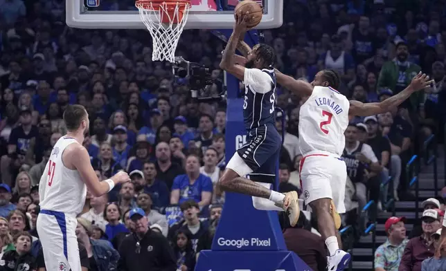 Dallas Mavericks forward Derrick Jones Jr. (55) goes for a dunk between Los Angeles Clippers' Ivica Zubac (40) and Kawhi Leonard (2) during the first half of Game 2 in an NBA basketball first-round playoff series Friday, April 26, 2024, in Dallas. (AP Photo/Tony Gutierrez)