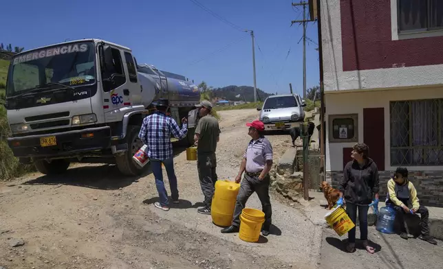 Residents collect water from a truck amid water rationing in La Calera, on the outskirts of Bogota, Colombia, Tuesday, April 16, 2024. Amid a drought linked to the El Niño weather pattern, several regions of Colombia have adopted measures to curb water consumption while reservoirs are low. (AP Photo/Fernando Vergara)