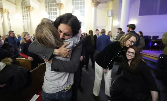 Tim Hernandez hugs Kallie Leyba as former Arizona Rep. Gabby Giffords, second from right, hugs Anne Marie Hochhalter, right during a vigil remembering the 25th anniversary of the Columbine High School mass shooting, Friday, April 19, 2024, in Denver. (AP Photo/Jack Dempsey)
