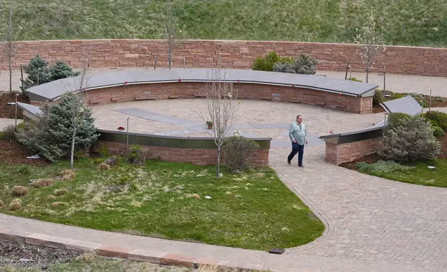 A visitor moves through the Columbine Memorial, Wednesday, April 17, 2024, in Littleton, Colo. Trauma still shadows the survivors of the horrific Columbine High School shooting as the attack's 25th anniversary approaches. (AP Photo/David Zalubowski)
