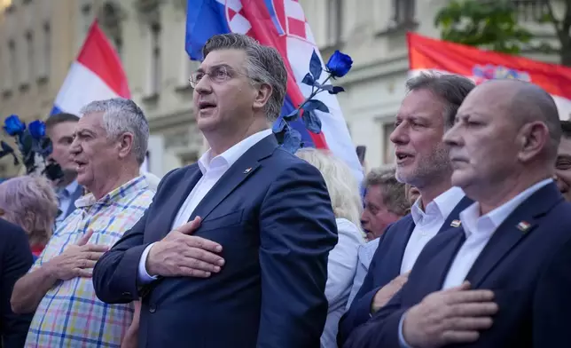 Prime Minister incumbent Andrej Plenkovic, centre, sings the nationals anthem during his party's rally in Zagreb, Croatia, Sunday, April 14, 2024. Croatia this week holds an early parliamentary election following a campaign that was marked by heated exchanges between the country's two top officials, creating a political crisis in the Balkan country, a European Union and NATO member state. (AP Photo/Darko Bandic)